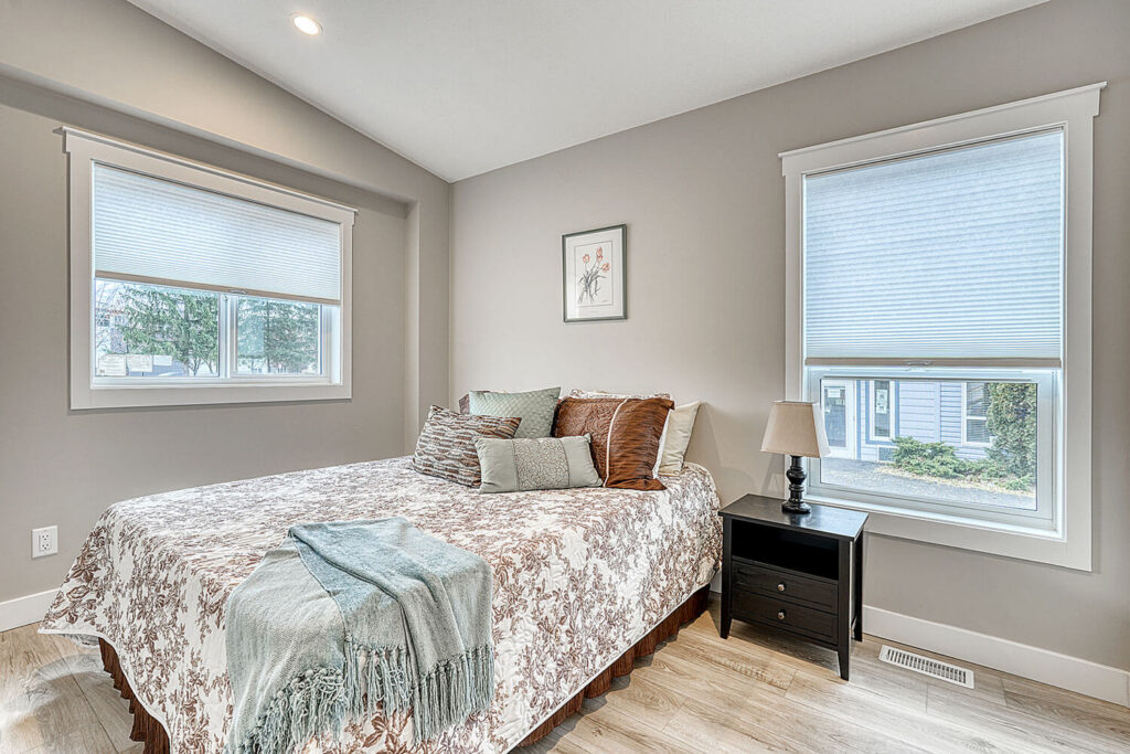 Guest bedroom with bright corner windows and inviting decor