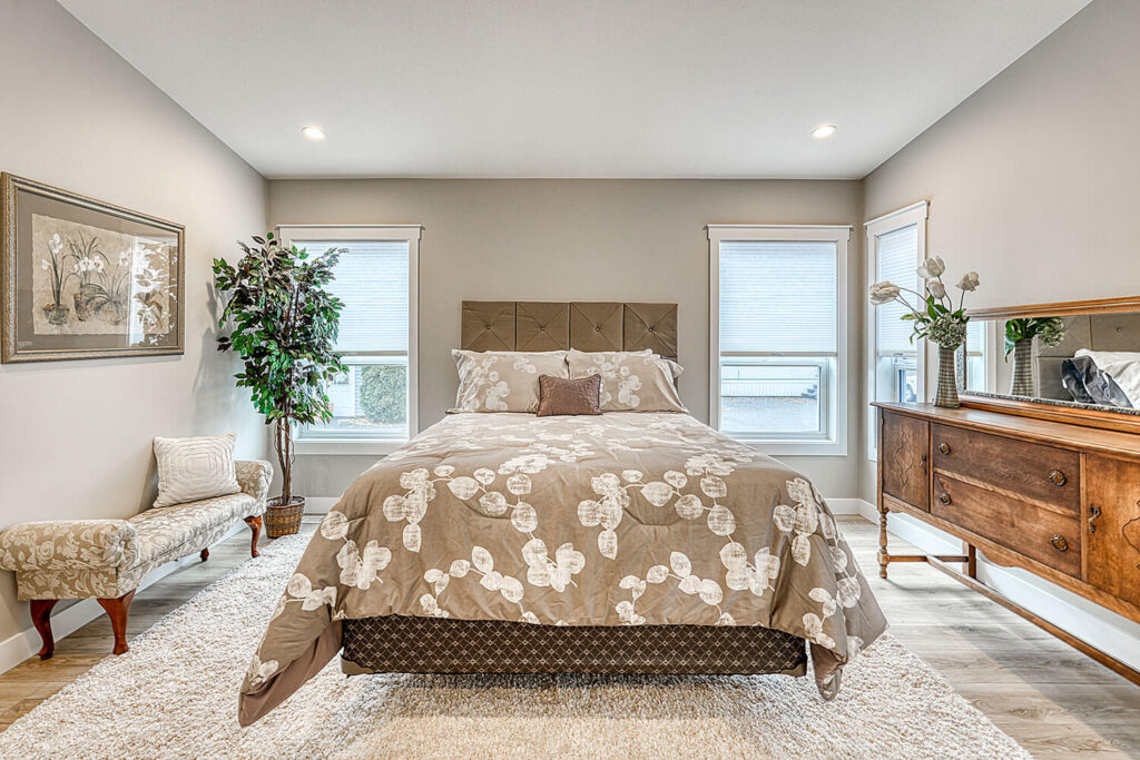 Master bedroom with tufted headboard and vintage dresser