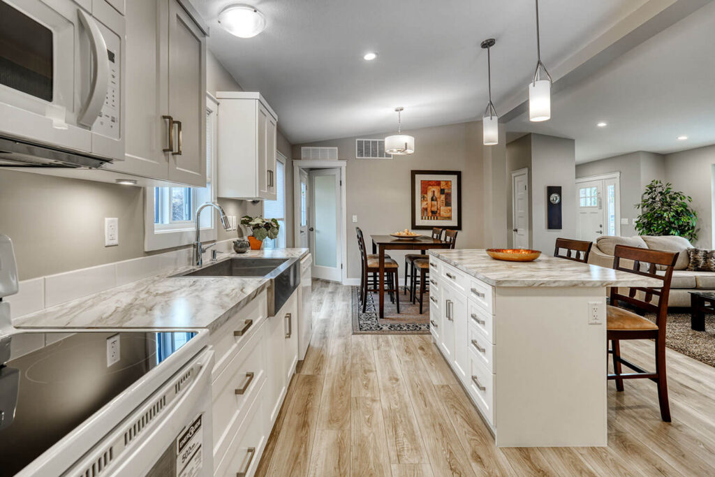 White kitchen with island, open to dining area, stainless appliances