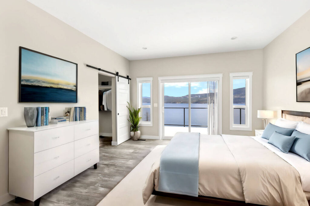 Master bedroom with lake and mountain views, barn door, and white dresser