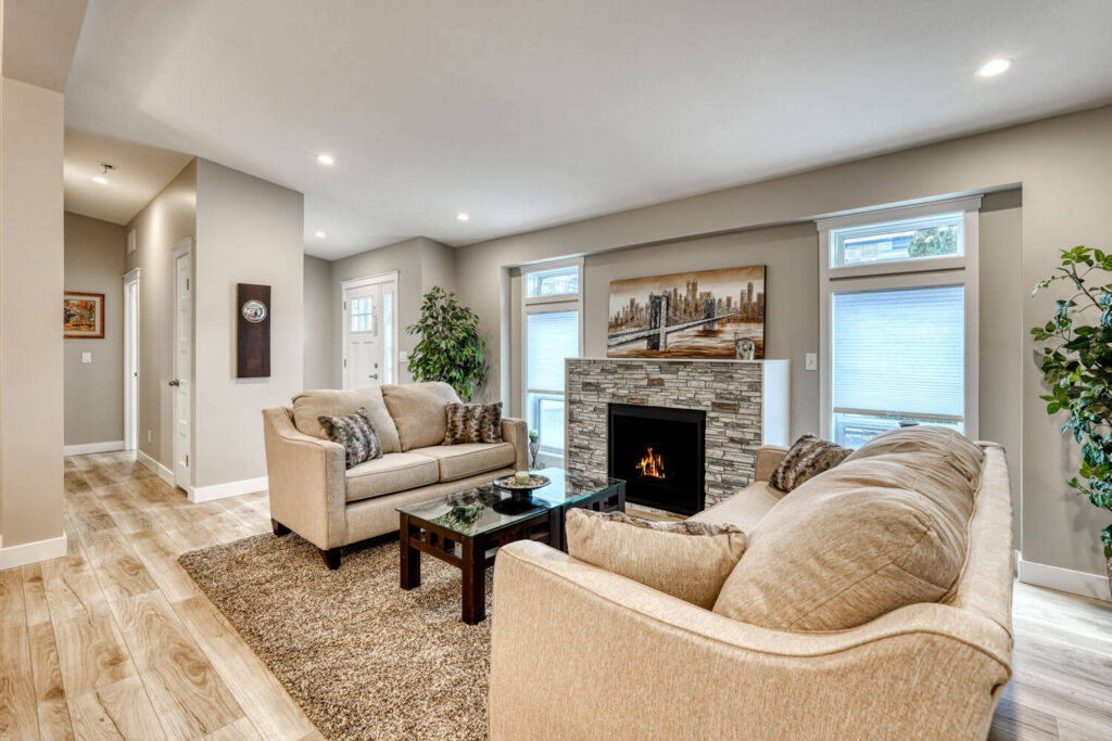 Open living area with stone fireplace and wide windows