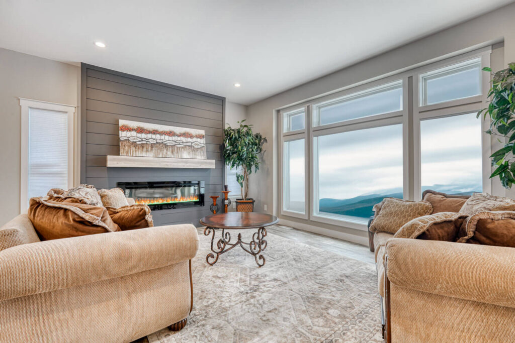 Shiplap fireplace feature wall with mountain views through floor-to-ceiling windows